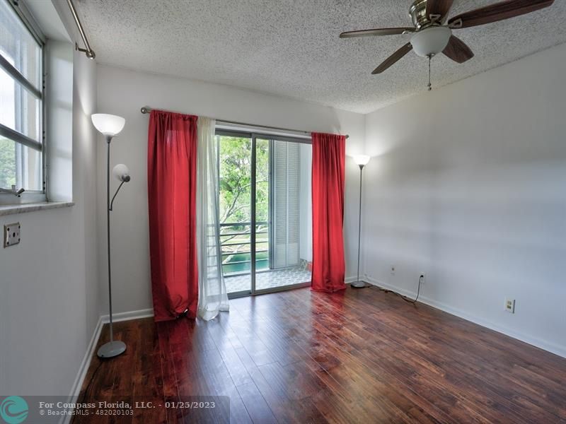 5160 Southwest 40th Avenue, Unit 29D Dania Beach, FL 33314 - Photo 15 of 31 a view of an empty room with window wooden floor and a chandelier fan