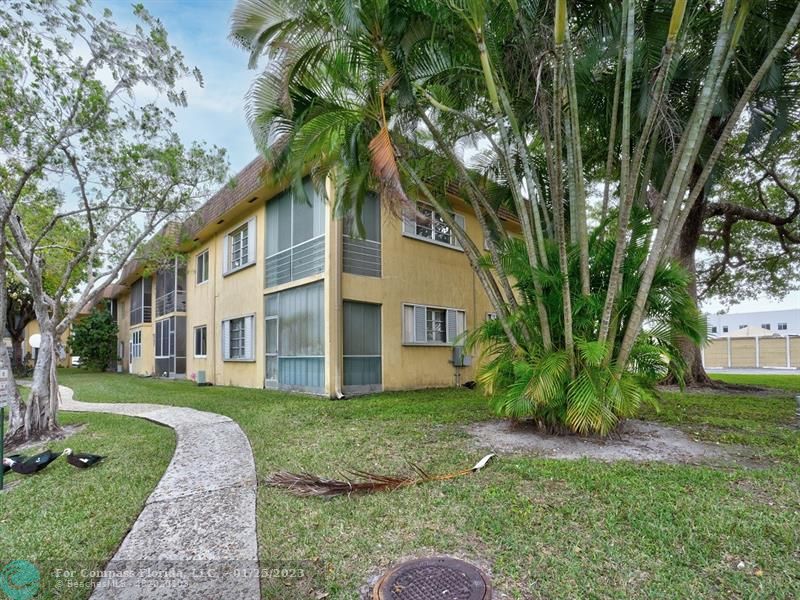 5160 Southwest 40th Avenue, Unit 29D Dania Beach, FL 33314 - Photo 2 of 31 a view of a white house next to a yard with big trees