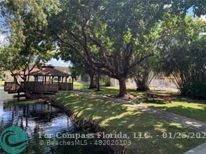 5160 Southwest 40th Avenue, Unit 29D Dania Beach, FL 33314 - Photo 29 of 31 a view of a yard with plants and a bench