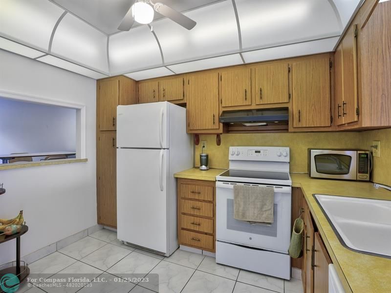 5160 Southwest 40th Avenue, Unit 29D Dania Beach, FL 33314 - Photo 6 of 31 a kitchen with a refrigerator and a stove top oven