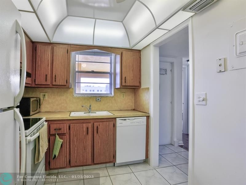 5160 Southwest 40th Avenue, Unit 29D Dania Beach, FL 33314 - Photo 7 of 31 a kitchen with a sink a stove cabinets and a window