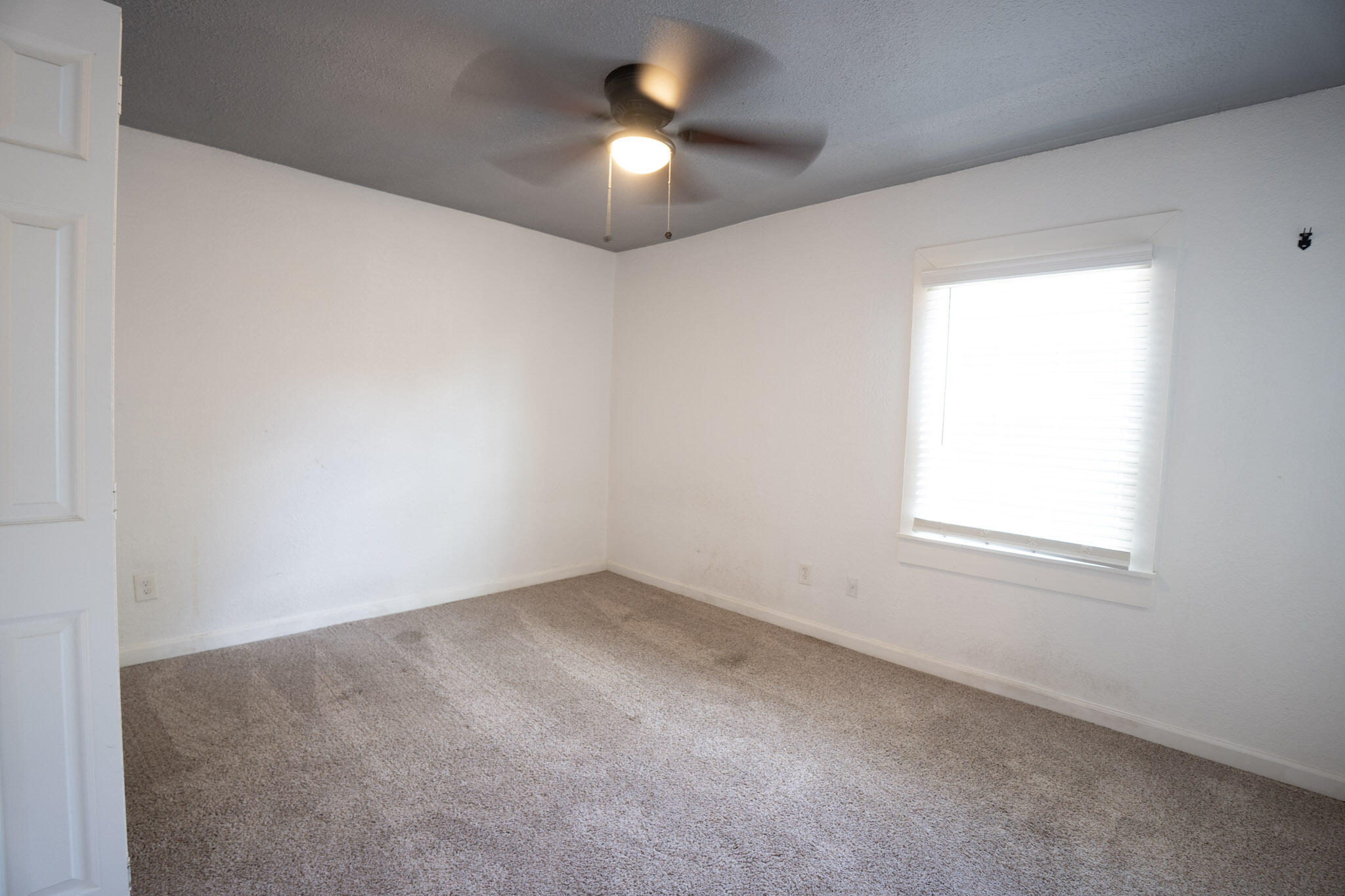3006 36th Street Lubbock, TX 79413 - Photo 14 of 16 an empty room with a chandelier fan and window