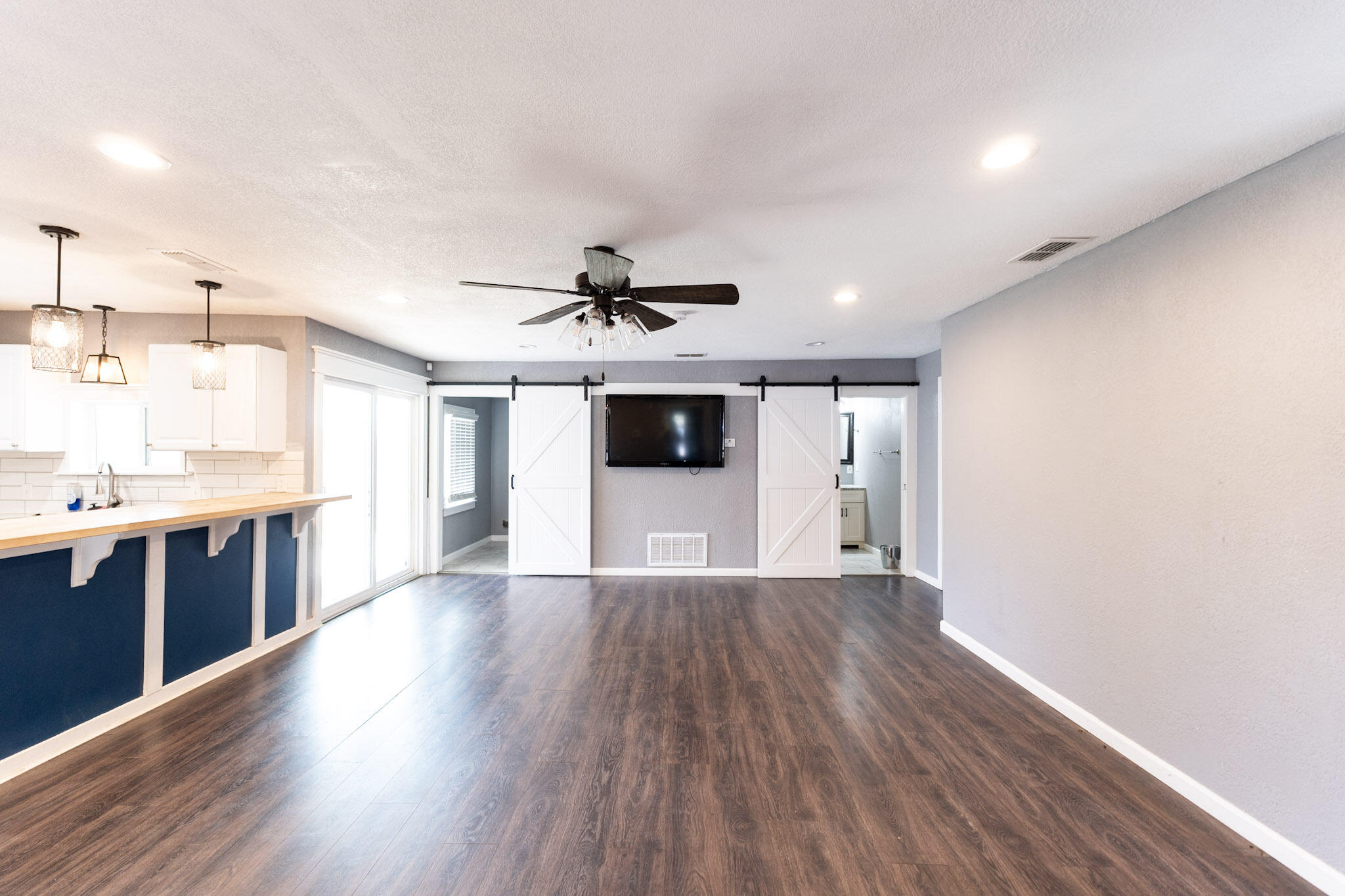 3006 36th Street Lubbock, TX 79413 - Photo 2 of 16 a view of a kitchen with wooden floor and a ceiling fan
