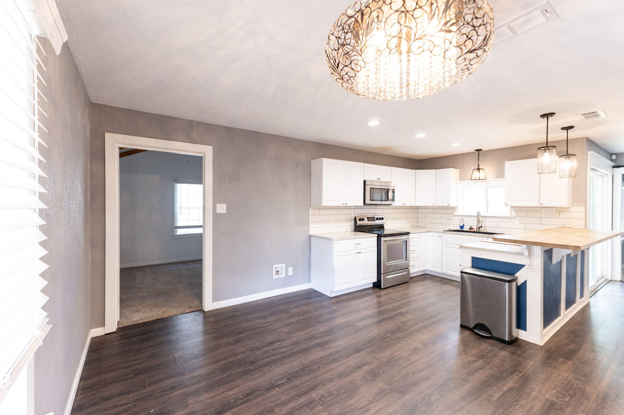 3006 36th Street Lubbock, TX 79413 - Photo 3 of 16 a kitchen with kitchen island white cabinets and stainless steel appliances
