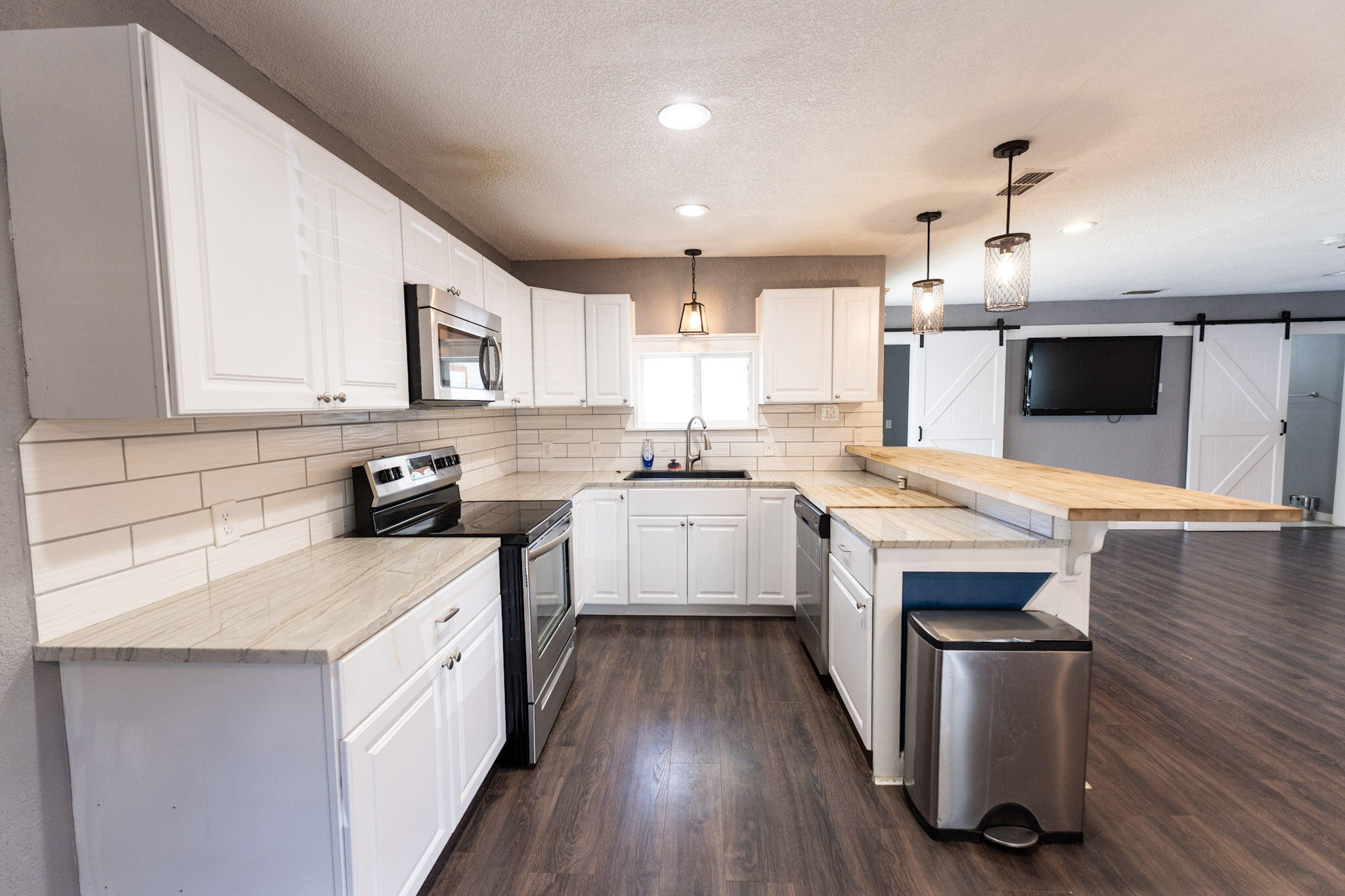 3006 36th Street Lubbock, TX 79413 - Photo 5 of 16 a kitchen with granite countertop a sink cabinets and stainless steel appliances