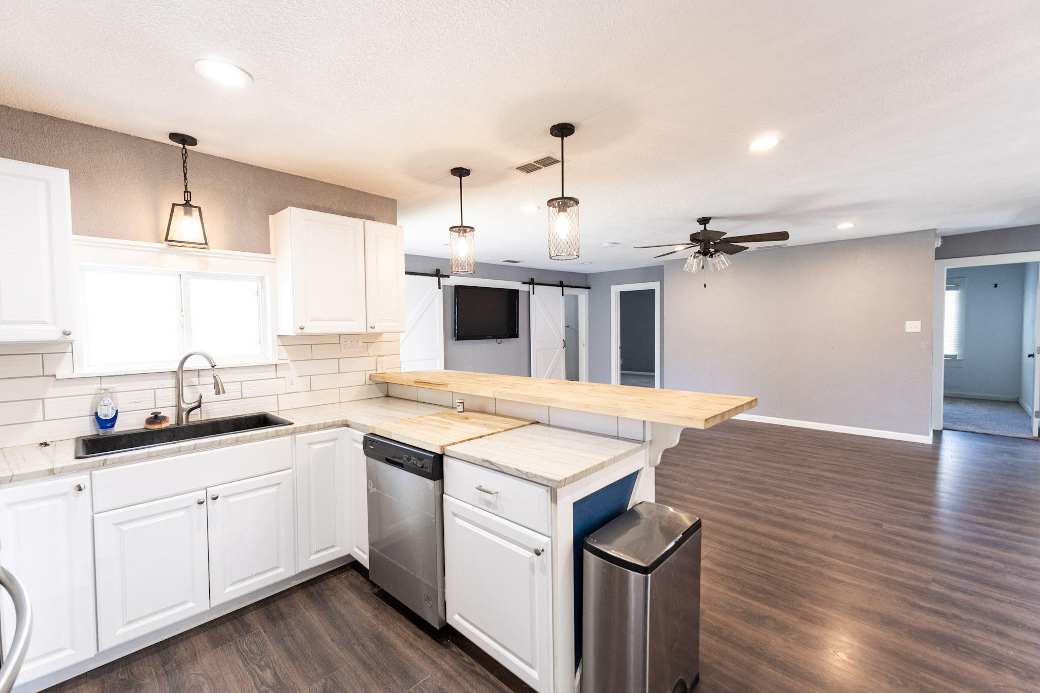 3006 36th Street Lubbock, TX 79413 - Photo 6 of 16 a kitchen with a sink a stove cabinets and wooden floor