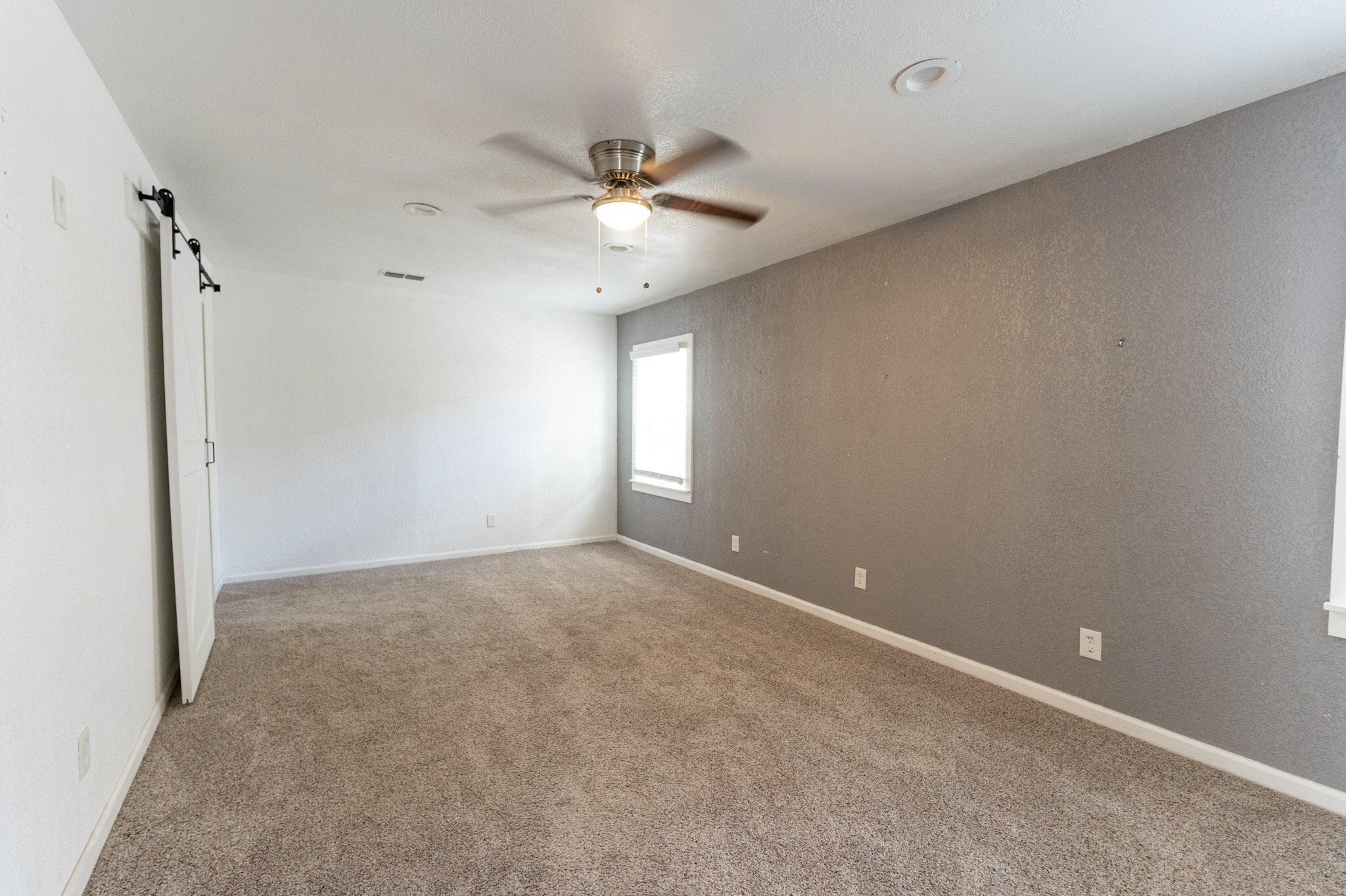 3006 36th Street Lubbock, TX 79413 - Photo 8 of 16 an empty room with a ceiling fan and a window
