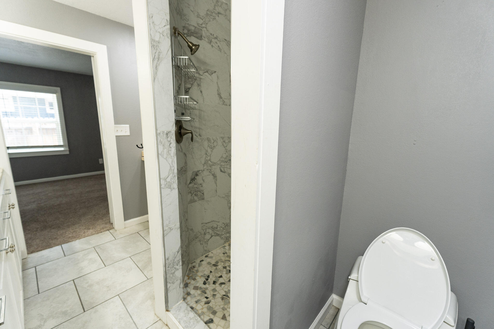3006 36th Street Lubbock, TX 79413 - Photo 10 of 16 a view of a bathroom with a glass door
