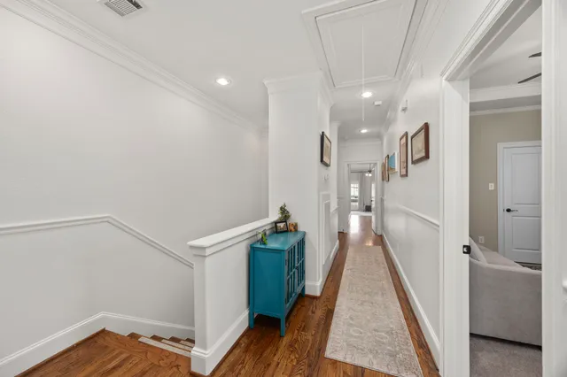 a view of a hallway with wooden floor and stairs