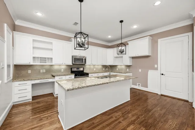 a kitchen with a sink stove and wooden floor