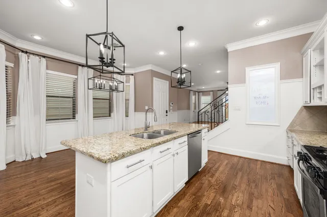 a open kitchen with a sink a center island and wooden floor