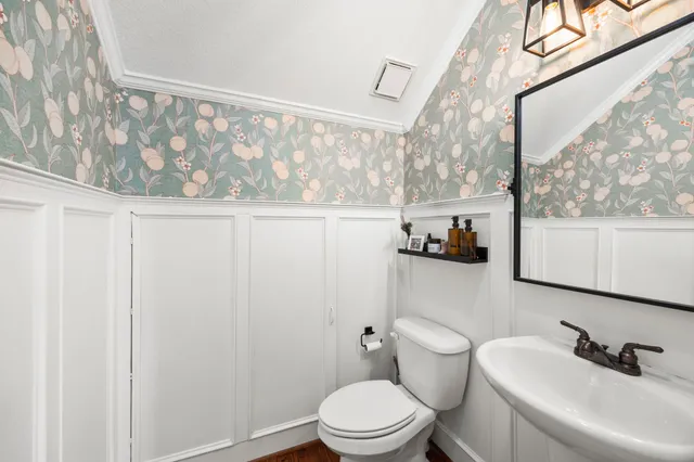 a bathroom with a sink toilet and a mirror