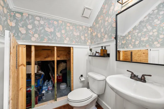 a bathroom with a toilet sink and mirror
