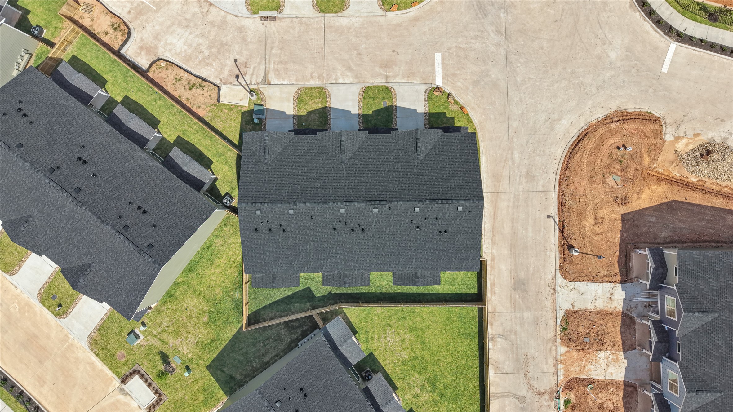 14010 Longstreet Road, Unit 2 Willis, TX 77318 - Photo 5 of 29 This aerial photo shows a new residential neighborhood with several modern homes featuring dark roofs and well-maintained lawns. The area appears to be under development, with some construction visible. Streets are paved and organized, offering a clean and accessible layout.