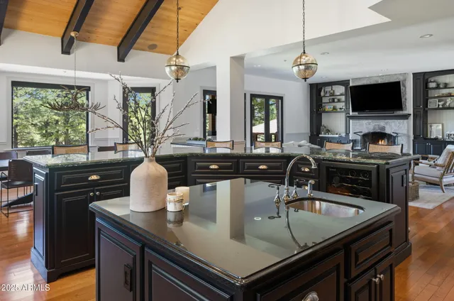 a kitchen with a stove a sink dishwasher a dining table and chairs with wooden floor