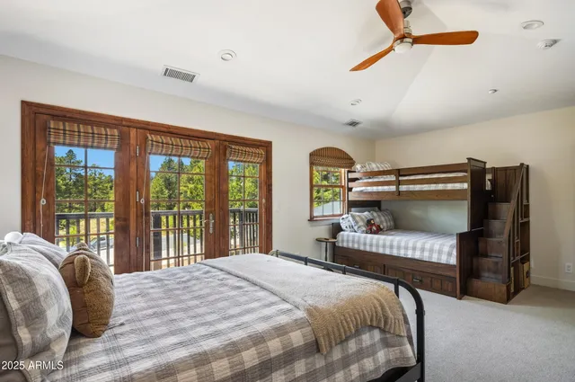 a bedroom with a bed a chandelier and a large window