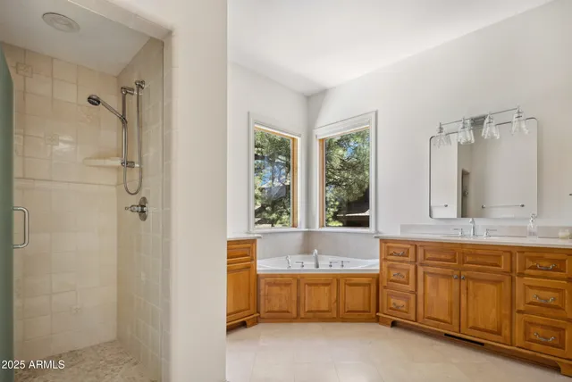 a bathroom with bathtub a shower a sink and mirror