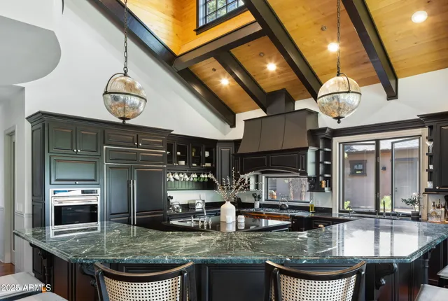 a kitchen with stainless steel appliances granite countertop a sink a stove and a wooden floors