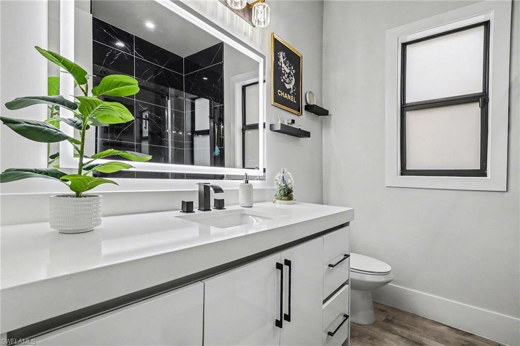 1720 21st Street Southwest Naples, FL 34117 - Photo 15 of 42 Full bathroom featuring vanity, dark wood-type flooring, and a marble finish shower
