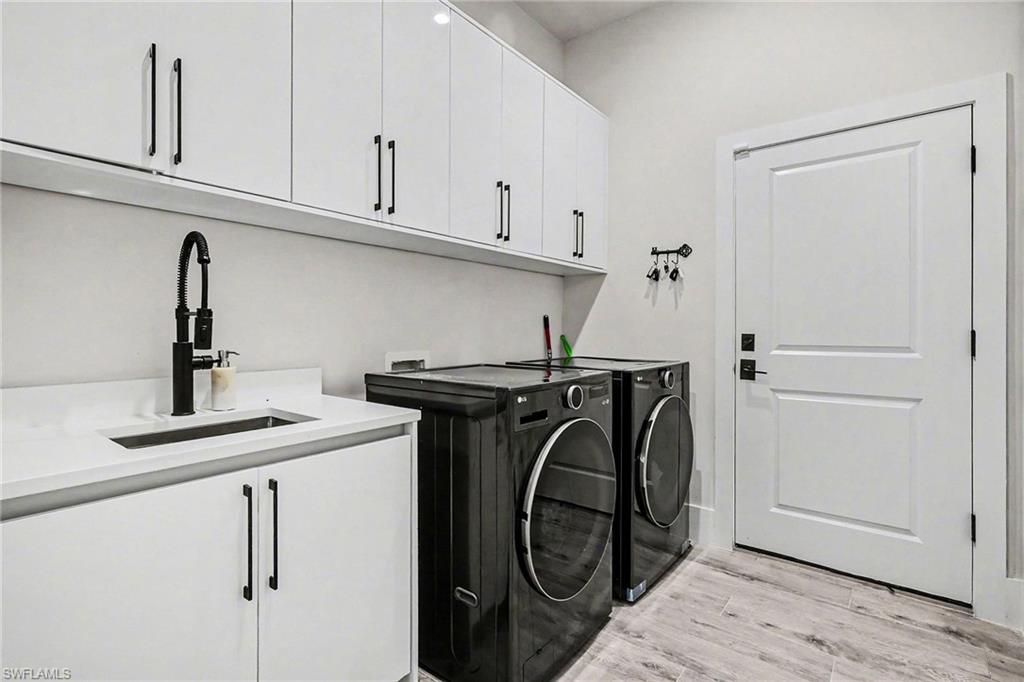 1720 21st Street Southwest Naples, FL 34117 - Photo 19 of 42 Washroom with light wood-style floors, cabinet space, and independent washer and dryer