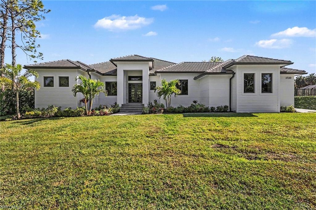 1720 21st Street Southwest Naples, FL 34117 - Photo 2 of 42 Prairie-style home featuring a tiled roof and a front yard