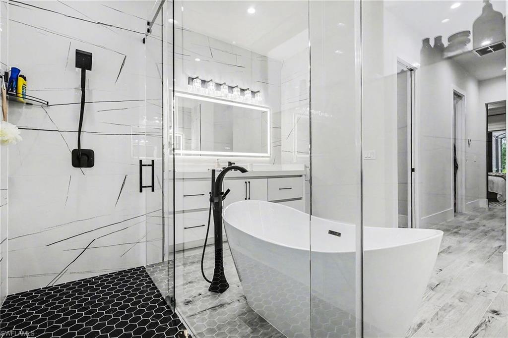 1720 21st Street Southwest Naples, FL 34117 - Photo 21 of 42 Full bath with a shower stall, a freestanding tub, recessed lighting, and wood finished floors