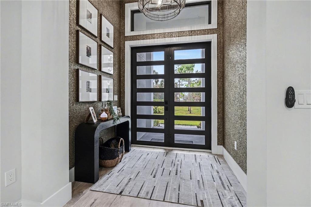 1720 21st Street Southwest Naples, FL 34117 - Photo 3 of 42 Foyer entrance featuring light wood-type flooring and textured walls