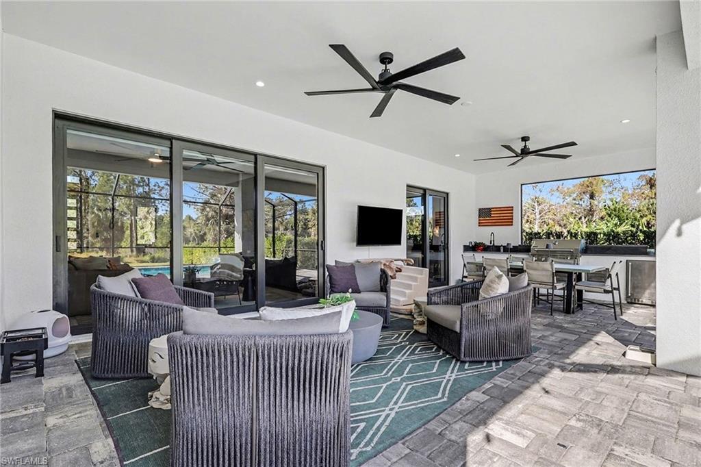 1720 21st Street Southwest Naples, FL 34117 - Photo 32 of 42 View of patio / terrace with an outdoor hangout area, outdoor dining area, ceiling fan, and exterior kitchen