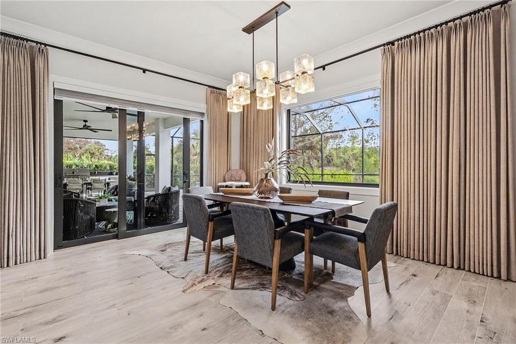 1720 21st Street Southwest Naples, FL 34117 - Photo 10 of 42 Dining space featuring a chandelier, light wood-type flooring, and a ceiling fan