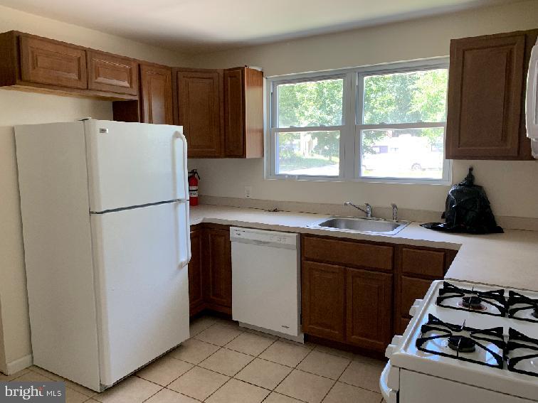 223 Dickinson Road Glassboro, NJ 08028 - Photo 4 of 10 a kitchen with a refrigerator and a sink