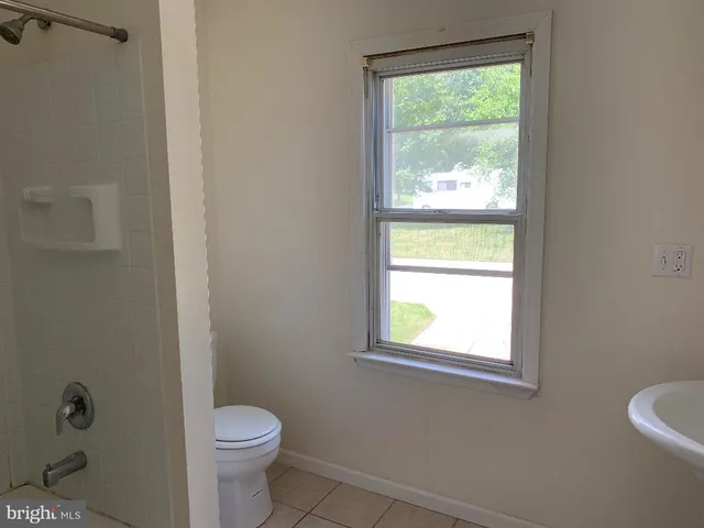 a bathroom with a toilet window and a shower