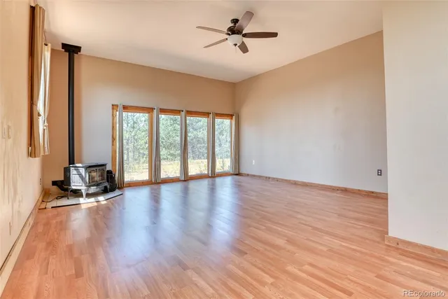 a view of room with hardwood floor and a ceiling fan