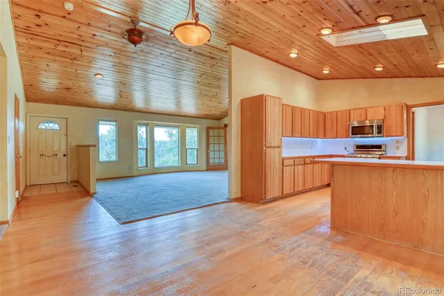 a view of kitchen with stainless steel appliances granite countertop a refrigerator and a stove