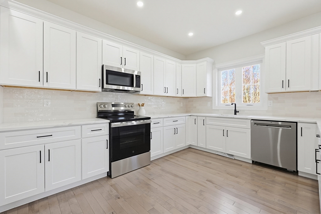 673 Pleasant Street Leicester, MA 01542 - Photo 12 of 38 a kitchen with white cabinets white stainless steel appliances and sink
