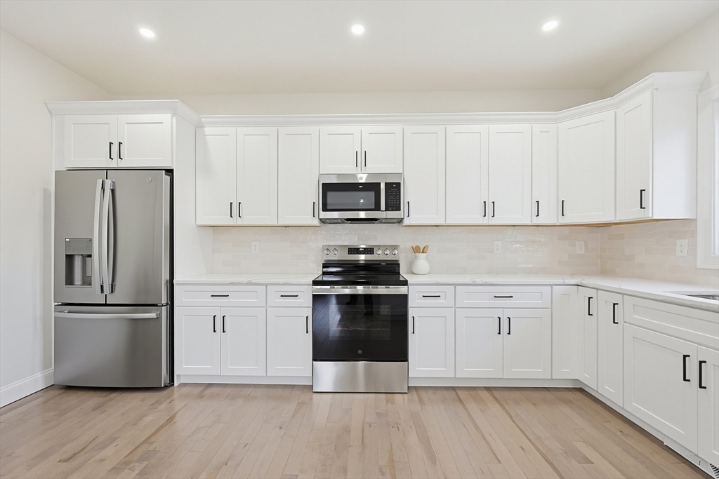 673 Pleasant Street Leicester, MA 01542 - Photo 13 of 38 a kitchen with cabinets stainless steel appliances and wooden floor