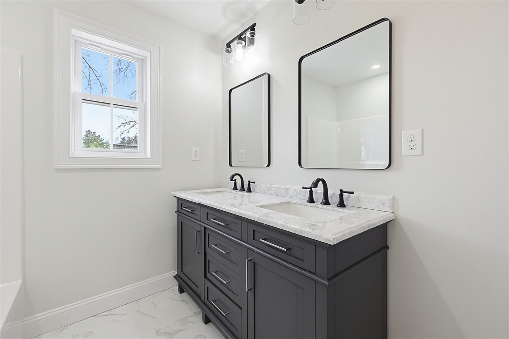 673 Pleasant Street Leicester, MA 01542 - Photo 20 of 38 a bathroom with a granite countertop sink a mirror and a