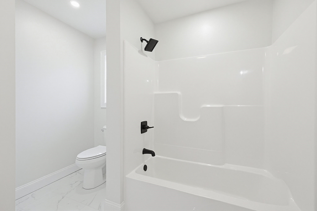 673 Pleasant Street Leicester, MA 01542 - Photo 25 of 38 a bathroom with a bathtub and a toilet