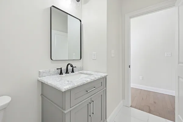 a bathroom with a granite countertop sink and a mirror