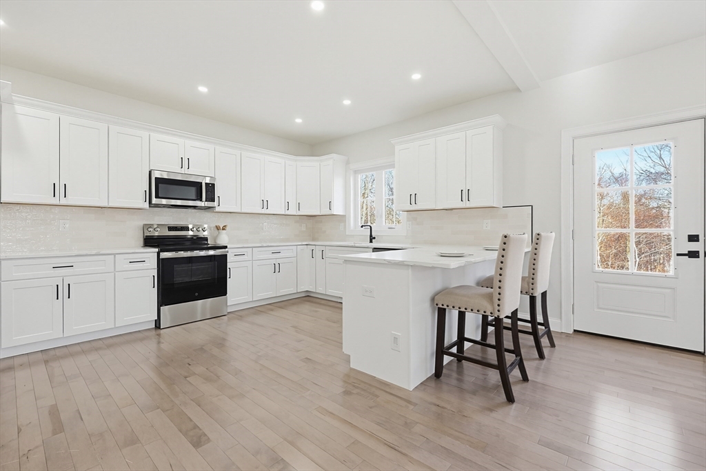 673 Pleasant Street Leicester, MA 01542 - Photo 10 of 38 a kitchen with granite countertop white cabinets and white appliances