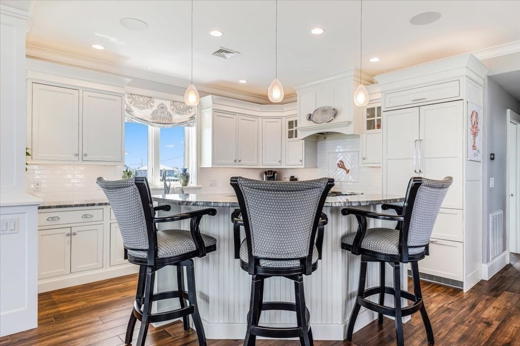 12 Monitor Road Marshfield, MA 02050 - Photo 13 of 42 a kitchen with a dining table chairs and white cabinets