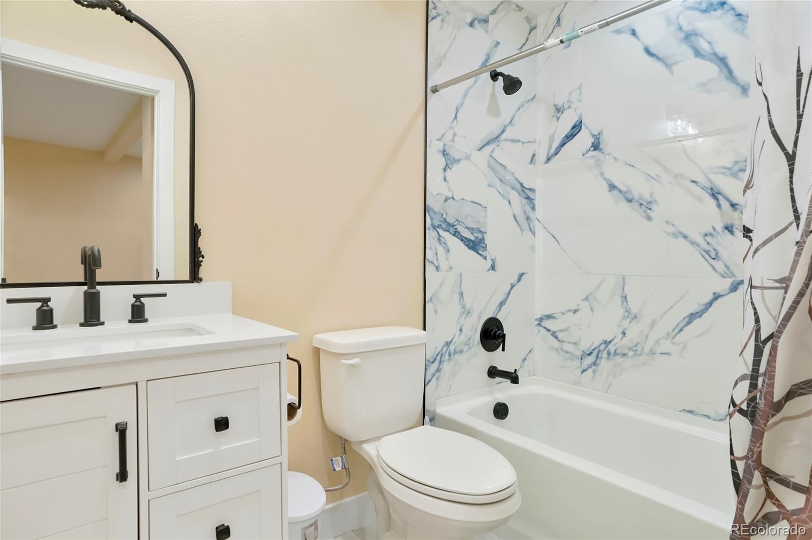 3161 Xmore Road Byers, CO 80103 - Photo 28 of 46 a bathroom with a bathtub shower sink vanity and toilet
