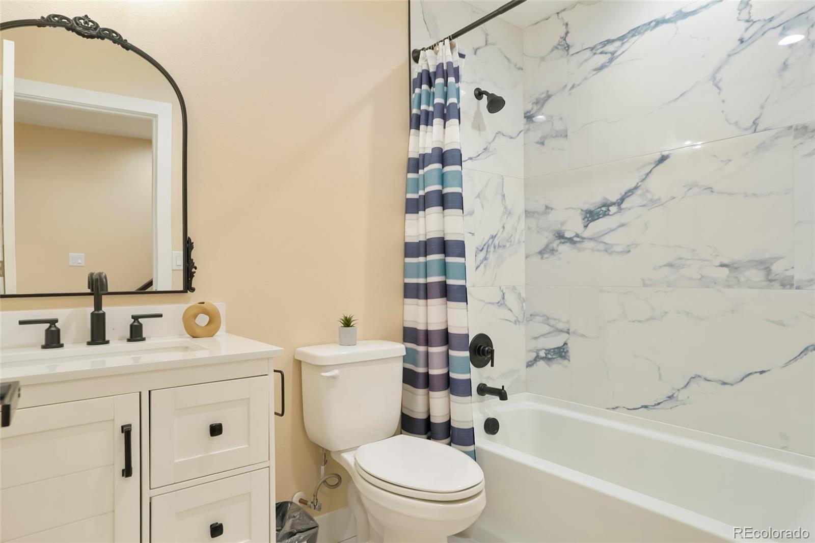3161 Xmore Road Byers, CO 80103 - Photo 33 of 46 a bathroom with a toilet sink vanity tub and shower