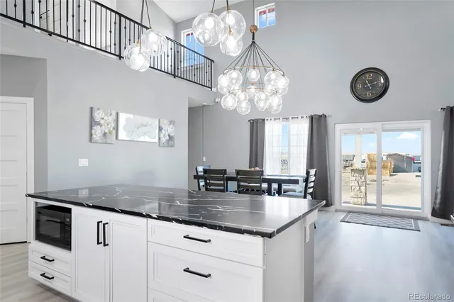 a kitchen with chandelier a stove and a clock on the wall