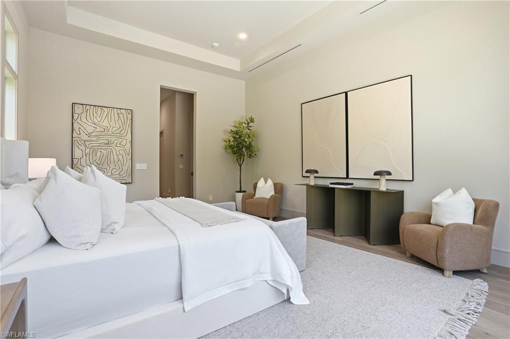 4851 Crayton Road Naples, FL 34103 - Photo 16 of 33 Bedroom featuring a tray ceiling and wood finished floors