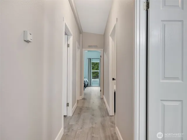 a view of a hallway with wooden floor and entryway