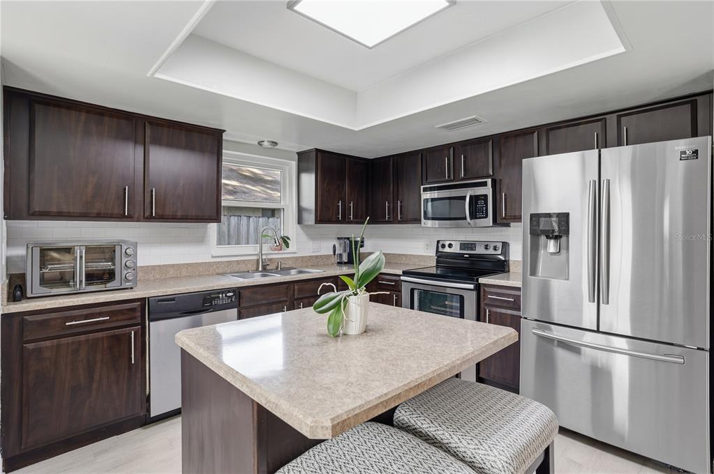 7550 Herricks Loop Orlando, FL 32835 - Photo 11 of 37 a kitchen with kitchen island a counter top space stainless steel appliances and cabinets