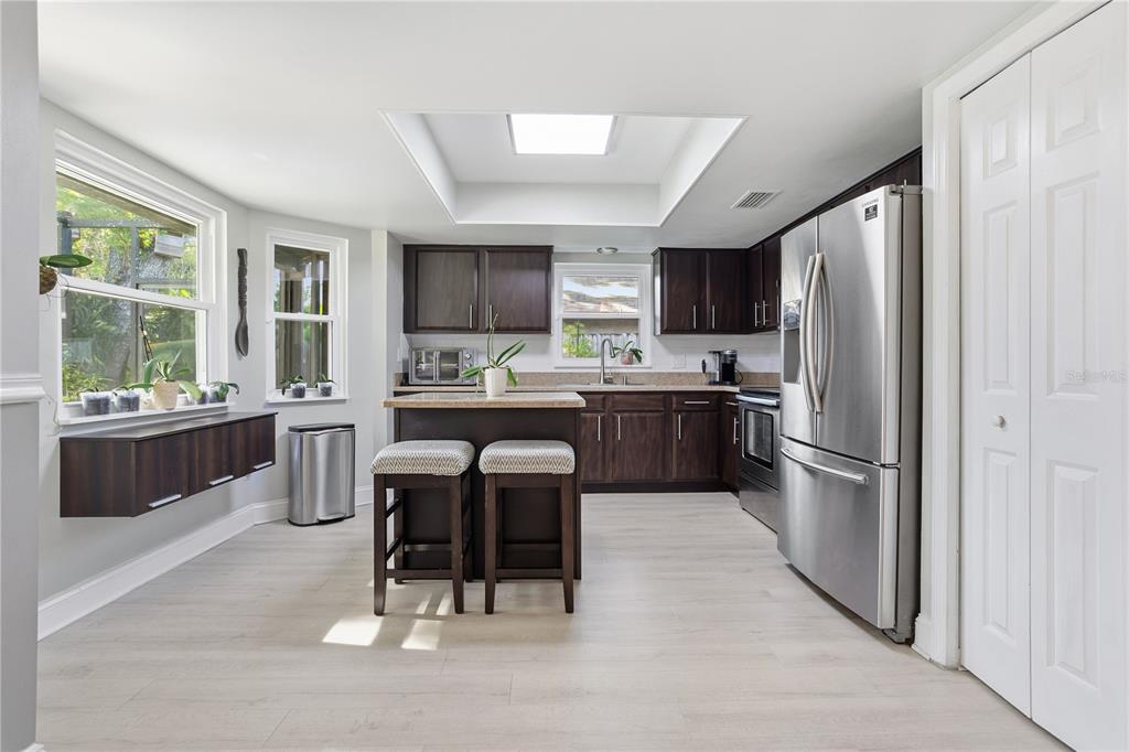 7550 Herricks Loop Orlando, FL 32835 - Photo 12 of 37 a kitchen with stainless steel appliances a refrigerator a sink a stove a microwave and chairs