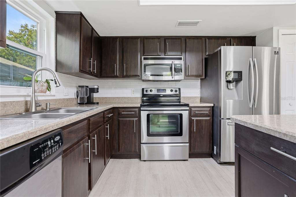 7550 Herricks Loop Orlando, FL 32835 - Photo 10 of 37 a kitchen with stainless steel appliances a sink cabinets and a refrigerator