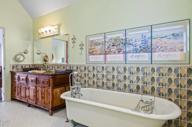 a bathroom with a bathtub a mirror and a sink