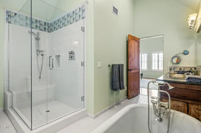 a bathroom with a shower a mirror and a sink